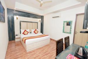 ein Schlafzimmer mit einem Bett mit roten Kissen darauf in der Unterkunft Roomsity Pride Delhi in Neu-Delhi