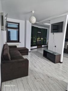 uma sala de estar com um sofá e uma televisão de ecrã plano em ЖК Актобе Ажары em Aqtöbe