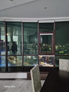 uma sala de jantar com vista para o horizonte da cidade em ЖК Актобе Ажары em Aqtöbe