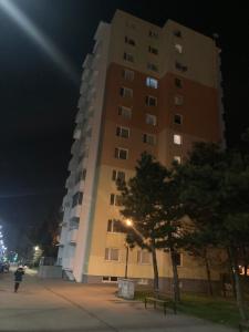 un edificio alto por la noche con una persona de pie junto a él en Dubravka, en Bratislava