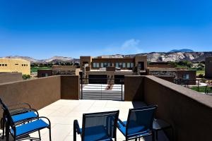 a balcony with chairs and a view of the mountains at Desert Cool in Ivins