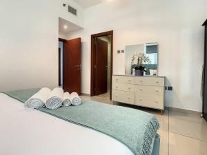 a bedroom with a bed with a dresser and a mirror at Key View - Marina Pinnacle in Dubai