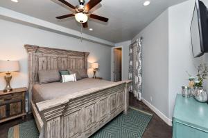 a bedroom with a large wooden bed with a ceiling fan at Desert Cool in Ivins