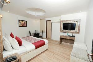 a bedroom with a bed and a flat screen tv at Airport Obsidian Oasis in New Delhi