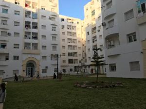 チュニスにあるLe Narjess Appartement Tunisの前方の公園のある建物群