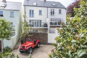 czerwony jeep zaparkowany przed domem w obiekcie Milford Street - 5 Bedroom Luxurious Holiday Home - Saundersfoot w mieście Saundersfoot