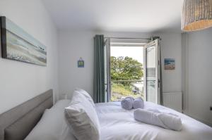 białe łóżko z 2 poduszkami i oknem w obiekcie Milford Street - 5 Bedroom Luxurious Holiday Home - Saundersfoot w mieście Saundersfoot
