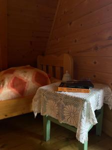 a bedroom with a bed and a table with a book on it at Black Wood in Žabljak