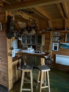 a kitchen with a counter and two stools in a cabin at Black Wood in Žabljak