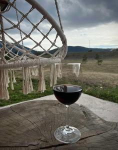 a glass of wine sitting on top of a table at Black Wood in Žabljak