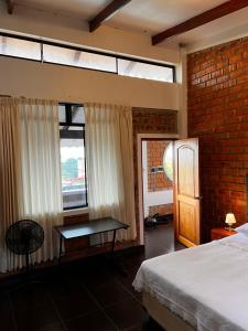 a bedroom with a bed and a table and windows at DELUX in Tarapoto
