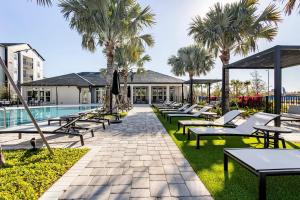 a row of chairs and tables next to a pool at Lush Green Retreat 10 Min to Parks Pets Allowed in Orlando