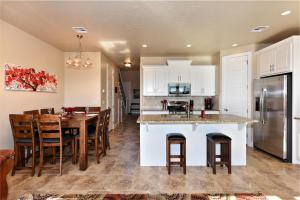 a kitchen with white cabinets and a table with chairs at Desert Dream in St. George