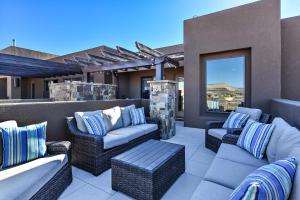 a patio with wicker chairs and couches on a balcony at Desert Dream in St. George