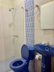 a bathroom with a blue toilet and a sink at Hostal Doña Nancy in Mompos
