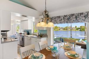 cocina y comedor con mesa y sillas en Smiling Dolphin Lake Front Home en Venice