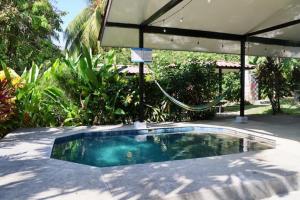 a swimming pool in a backyard with an umbrella at Walk to the beach, chill by the pool. Casa Sol! in Pavones
