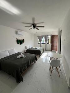 a bedroom with two beds and a ceiling fan at ALMAR FAMILY HOUSE in Holbox Island