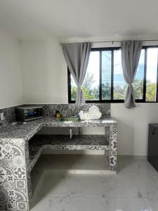 a stone bench in a room with windows at ALMAR FAMILY HOUSE in Holbox Island