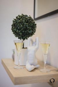 una mesa con dos copas de vino y una estatua de un conejo en Apartman "Enso" I Pozega, Serbia, en Požega