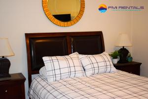 een slaapkamer met een bed met een spiegel aan de muur bij Marina Pinacate B-408 in Puerto Peñasco