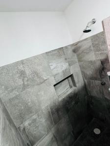 y baño con ducha y suelo de baldosa. en ALMAR FAMILY HOUSE en Isla Holbox