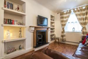 a living room with a couch and a fireplace at Shell Cottage - 2 Bedroom Holiday Home - Tenby in Tenby