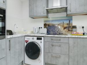 a kitchen with a washing machine in a kitchen at Sunny View in Dawlish