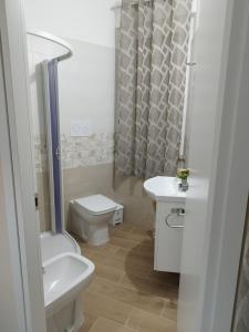 een witte badkamer met een toilet en een wastafel bij L'Angolo di Sarah in Santo Stefano di Camastra