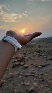 a person holding their hand up to the sunset at LUNA del DESIERTO TATACOA in Villavieja