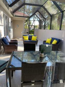 a patio with a glass table and chairs at Charming, Victoria in Naples
