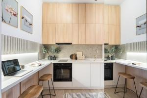 a kitchen with white countertops and wooden cabinets at Pitar Mos - Downtown Bucharest in Bucharest