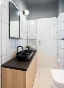 a bathroom with a black sink and a toilet at Pitar Mos - Downtown Bucharest in Bucharest +23 photos