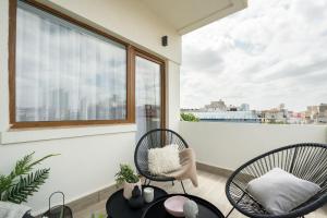 a balcony with two chairs and a table and a window at Pitar Mos - Downtown Bucharest in Bucharest