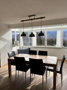 una sala da pranzo con tavolo e sedie in legno di Lakeviewhouse a Sundlauenen