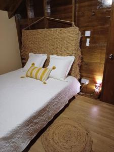 um quarto com uma cama com lençóis brancos e almofadas amarelas em Cottage Haven Escape em Portsmouth