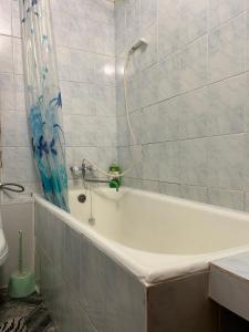 La salle de bains est pourvue d'une baignoire et d'une douche. dans l'établissement Недорога квартира на Харківській, 32, à Soumy