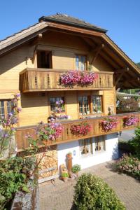 a wooden house with flowers on the balcony at Apartment Bühlmann in Spiez