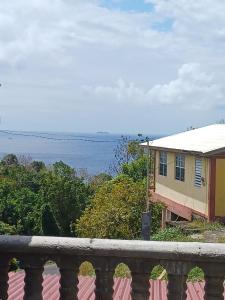 a house with a balcony with the ocean in the background at Cottage Haven Escape in Portsmouth