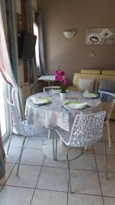 a dining room table with chairs and a white table cloth at résidence lac de La Sole T3 4 pers les minimes avec piscine in La Rochelle