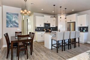 a kitchen with white cabinets and a table and chairs at Eagle's Ledge in St. George
