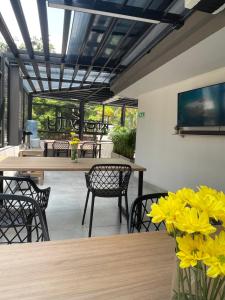 a dining room with a table and chairs and yellow flowers at Hotel Casa Kreenty in Cali