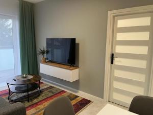 a living room with a flat screen tv on a wall at Apartament Zacisze 14 in Piaseczno