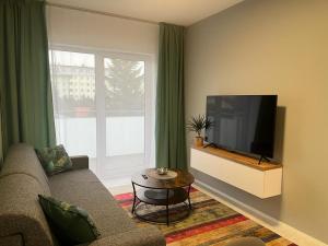 a living room with a couch and a flat screen tv at Apartament Zacisze 14 in Piaseczno