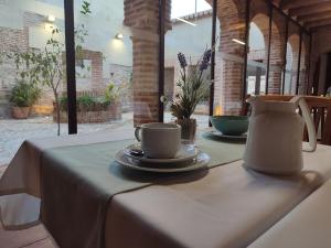 a table with a tea pot and cups on it at casa rural Cieza de León in Llerena