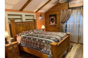 1 dormitorio con 1 cama en una habitación con pared de madera en Stockyards-Walk 1 Block to StockYards-Cowboy Cabin, en Fort Worth