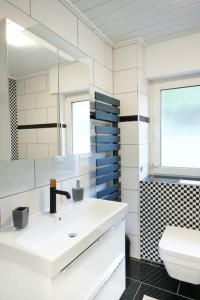 Baño blanco con lavabo y aseo en Meinerzhagen - Schöne Unterkunft mit Kamin, en Meinerzhagen