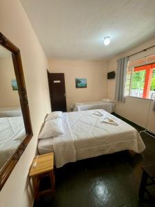 Habitación de hotel con 2 camas y espejo en A S Suites en Angra dos Reis