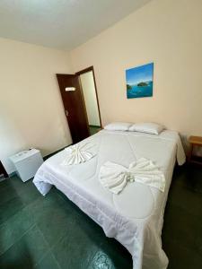 安格拉杜斯雷斯的住宿－A S Suites，卧室配有白色的床,上面有弓