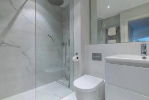 y baño con ducha, aseo y lavamanos. en Chic Urban Haven 3BR Flat in Clarendon Court, en Londres